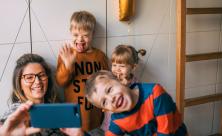 mom taking selfie with three kids